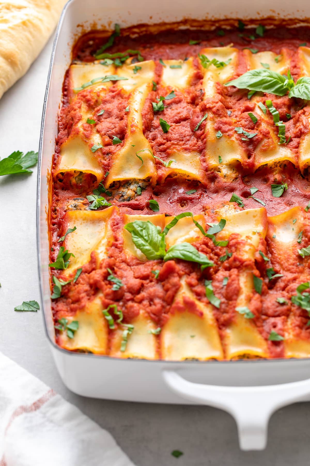 side angle view of freshly baked vegan cannelloni in a baking dish.