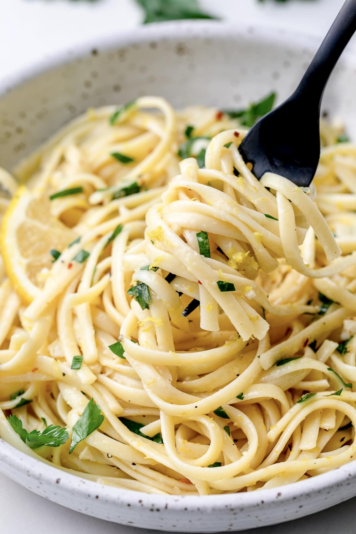 side angle view of fork swirled in lemon pasta.