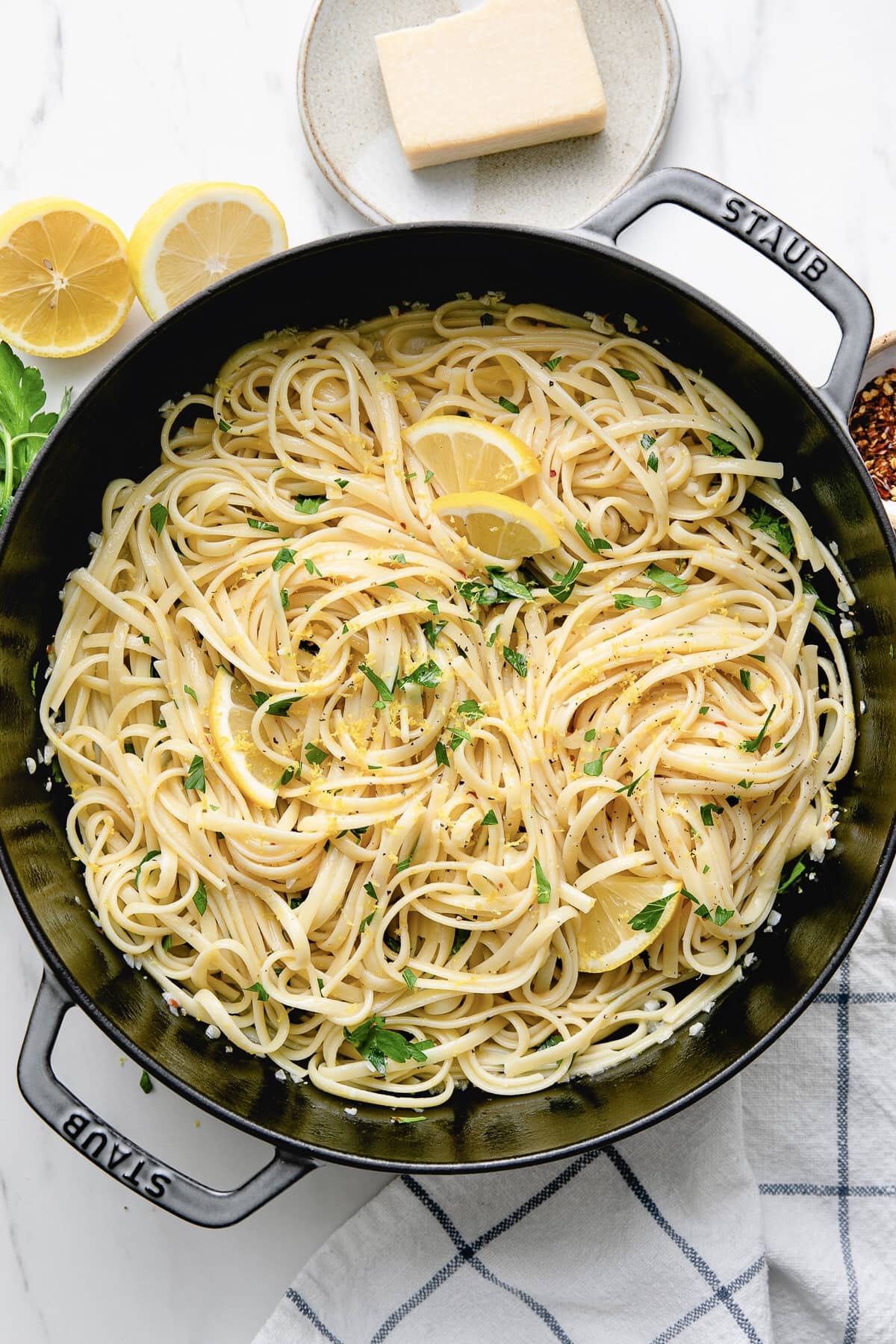 top down view of simple lemon pasta in a pot with items surrounding.