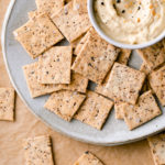 top down view of almond flour crackers on a plate with items surrounding.