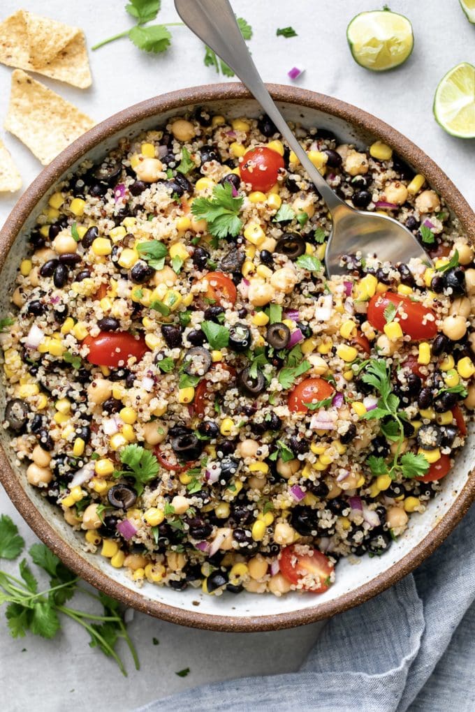 top down view of freshly made southwest quinoa salad in a serving bowl with spoon.