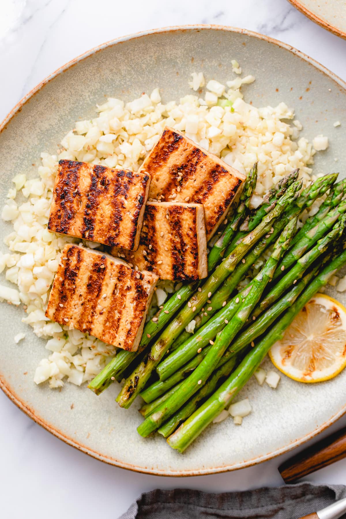 top down view of grilled tofu and asparagus with cauliflower rice.