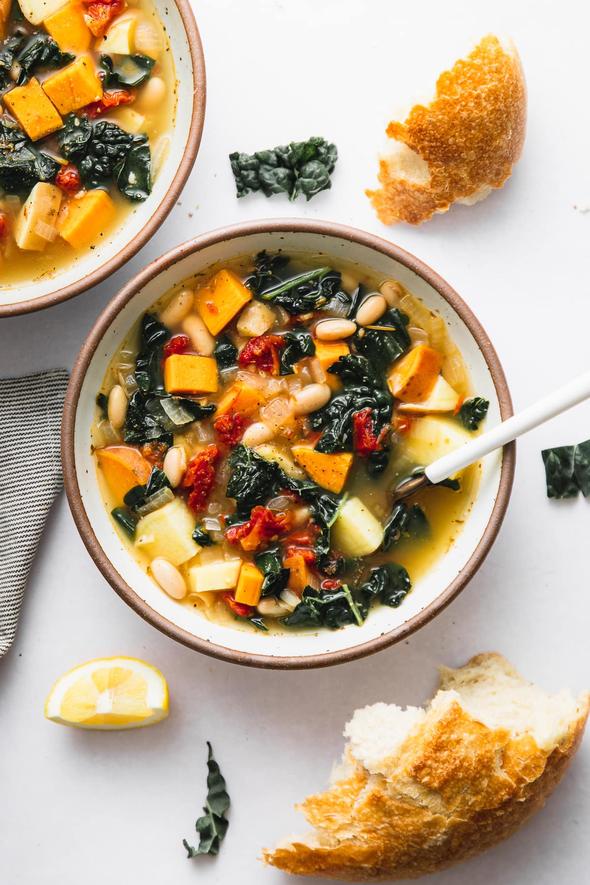top down view of sweet potato kale soup in a bowl with items surrounding.