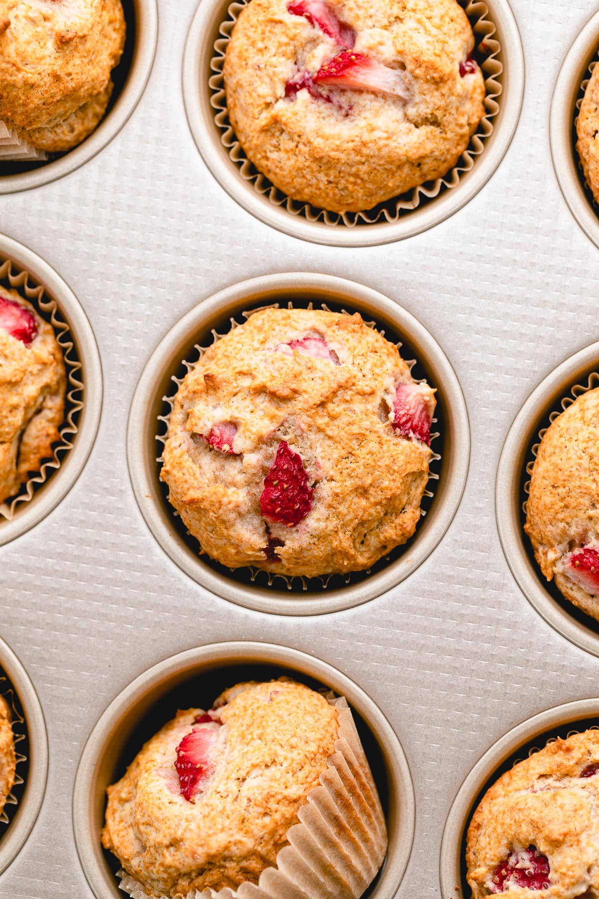 top down view of freshly baked strawberry banana muffins up close in muffin tin.