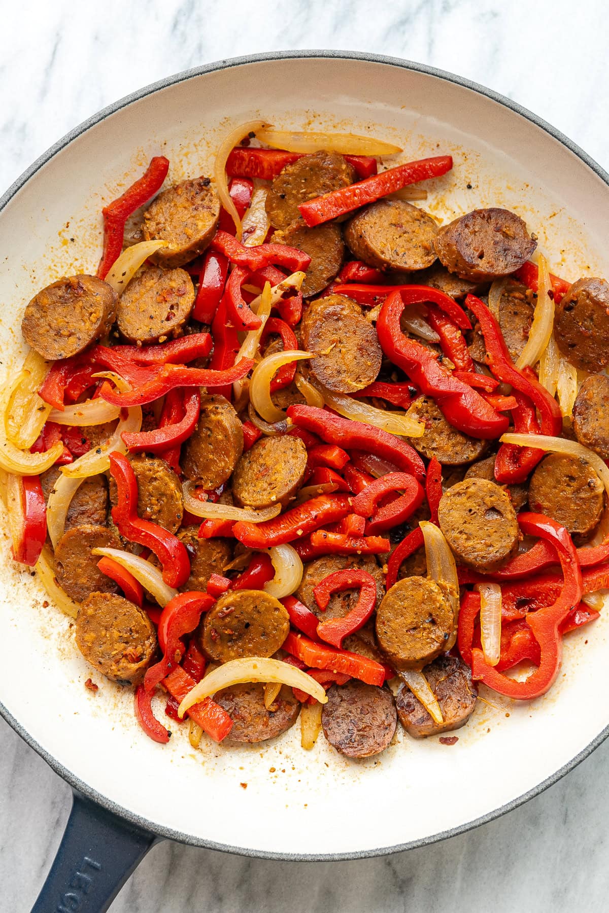 top down view of peppers, onion, and vegan Italian sausage freshly made in a skillet.
