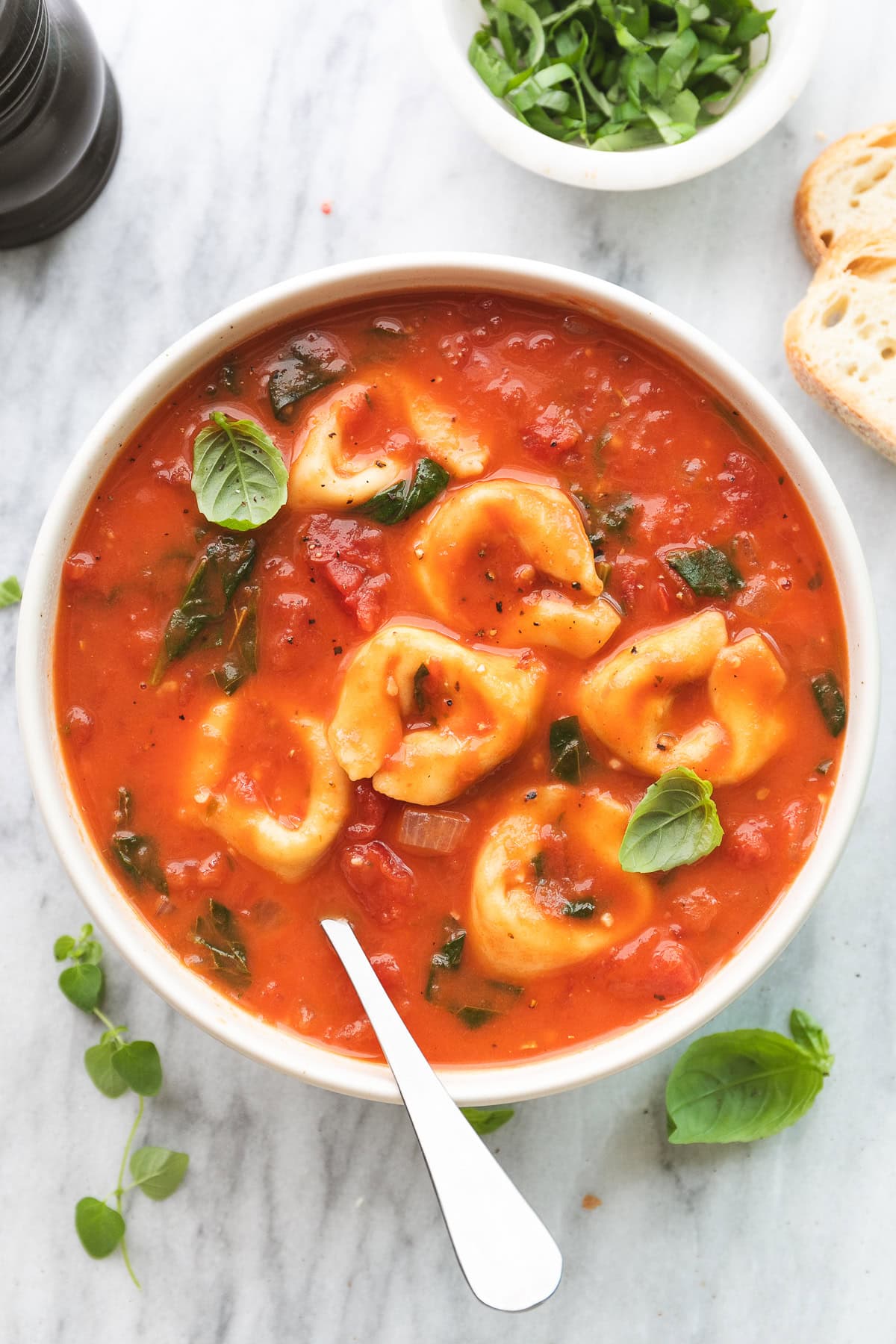 up close view of tomato tortellini soup in a bowl with spoon.