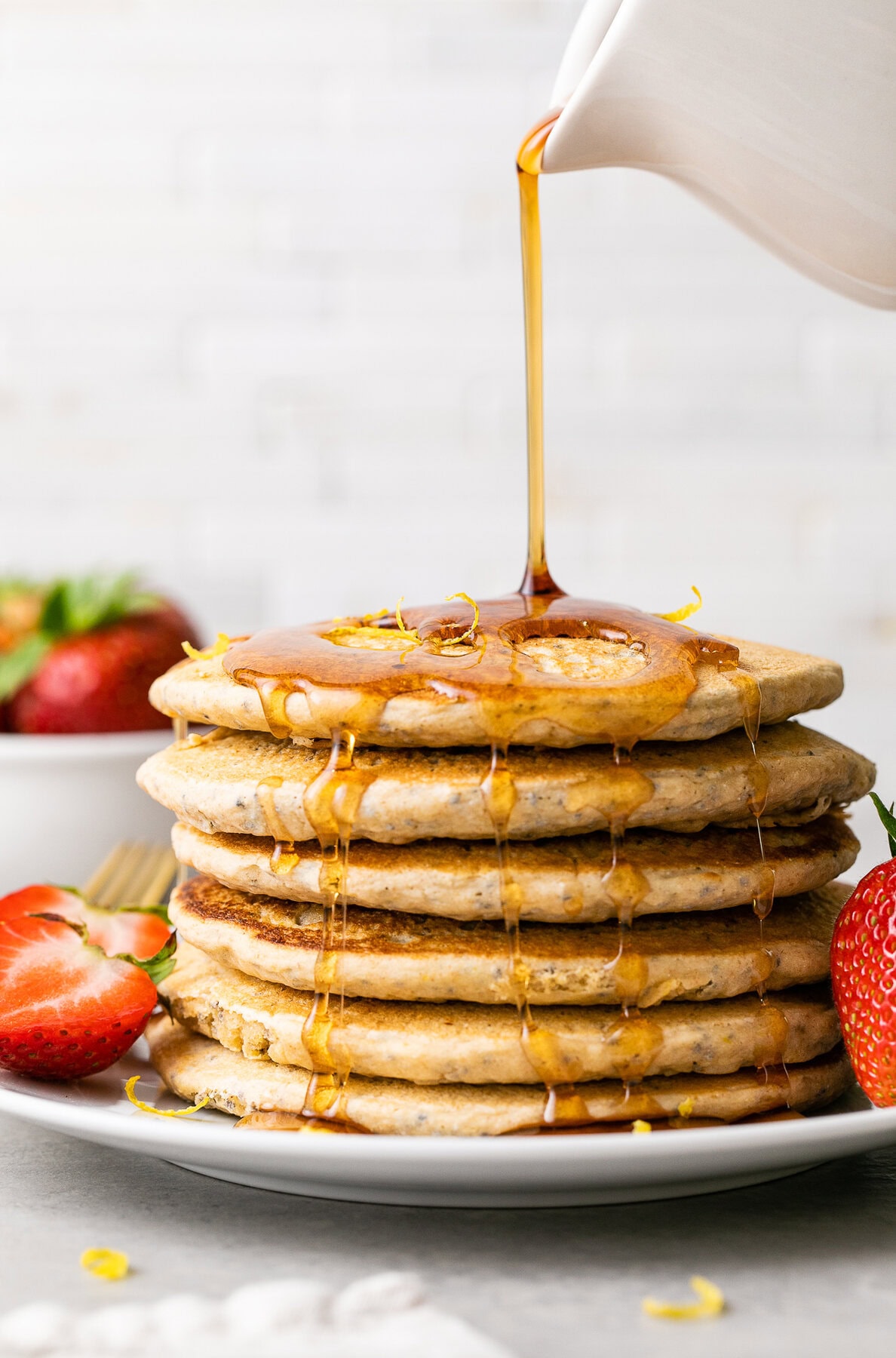 vegan lemon chia seed pancakes with maple syrup and berries.