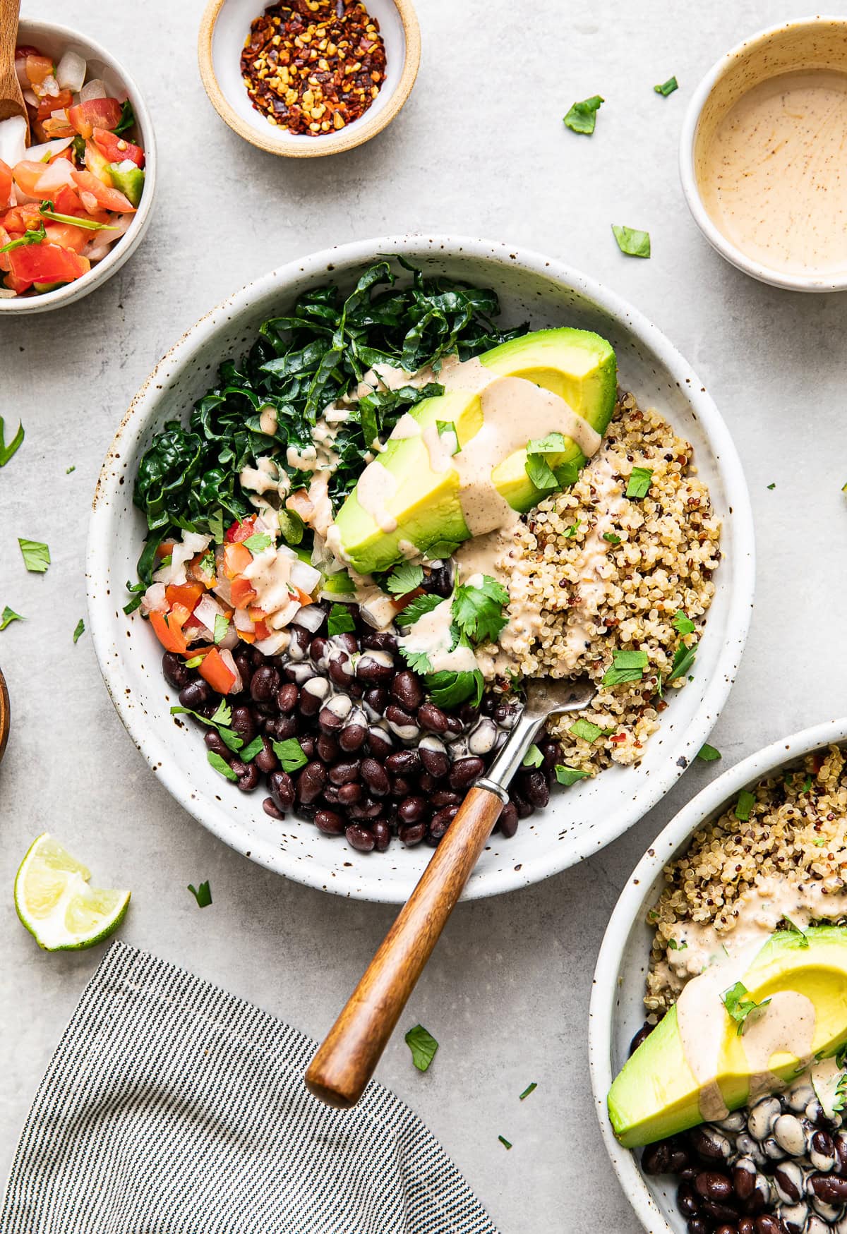 healthy vegan grain bowl with quinoa, kale, black beans, and cashew dressing.