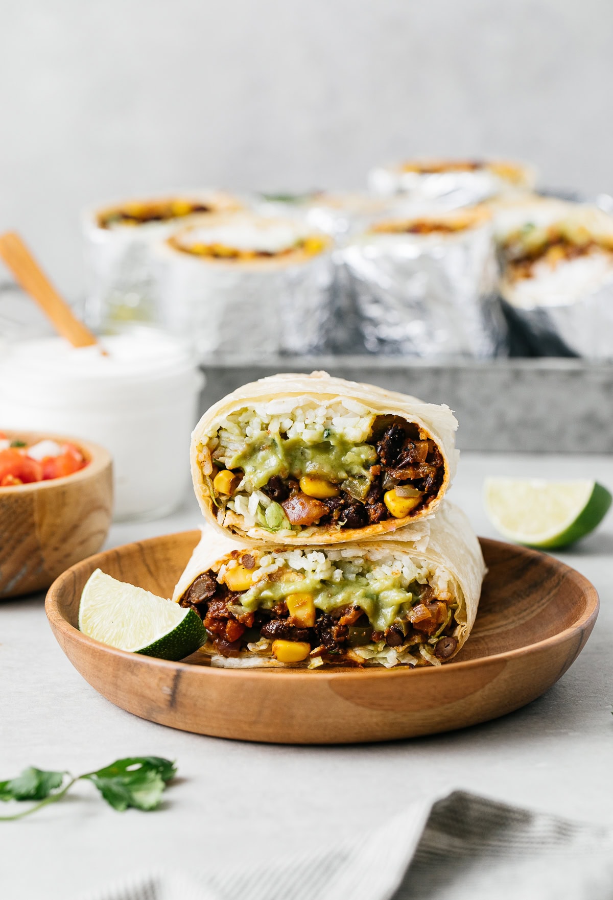 vegan burrito with sofrito, beans, rice, and guacamole cut in half and stacked.