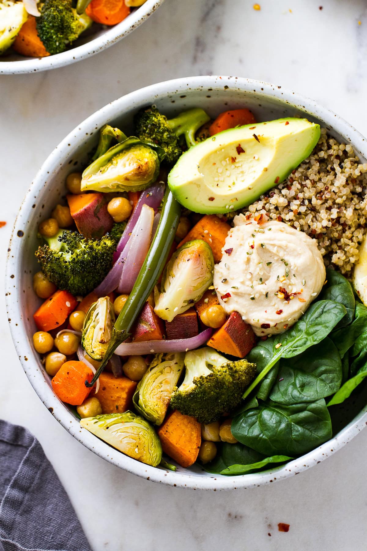 vegan dinner bowl with quinoa, veggies, and hummus.