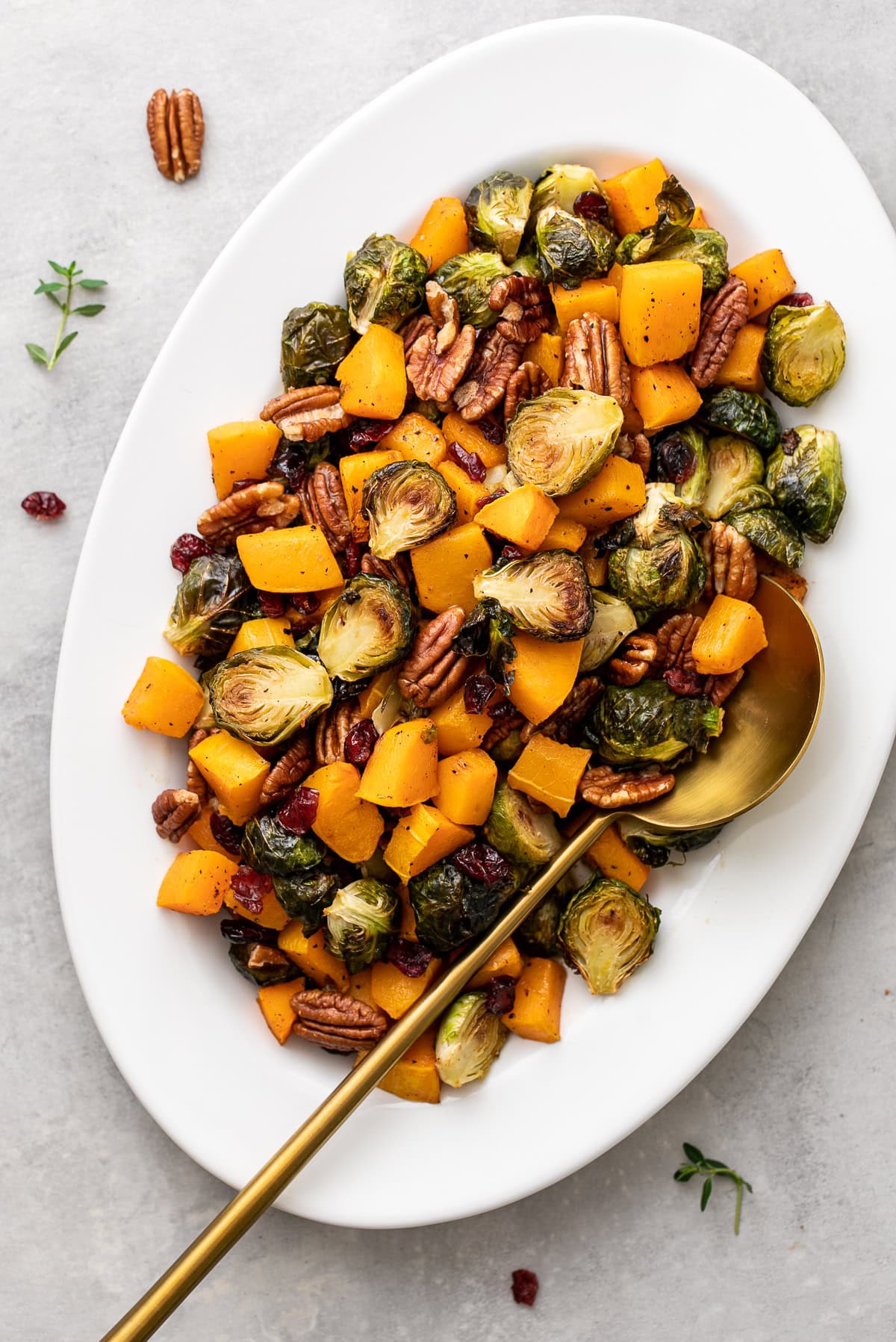 top down view of a platter with festive holiday side with roasted brussels sprouts, butternut squash, cranberries and pecans.