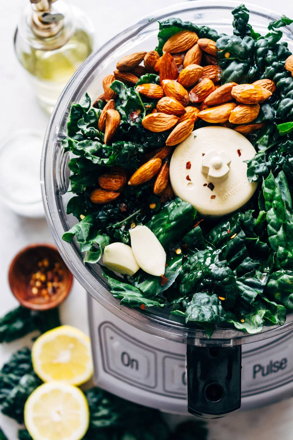 vegan kale pesto ingredients in food processor before processing.