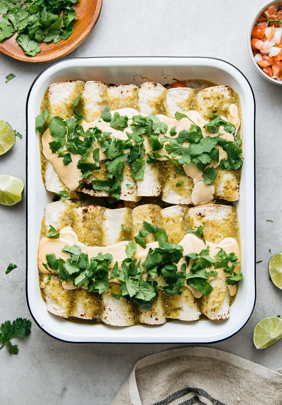 top down view of vegan enchiladas with tomatillo sauce and spicy cashew cream, topped with fresh cilantro.