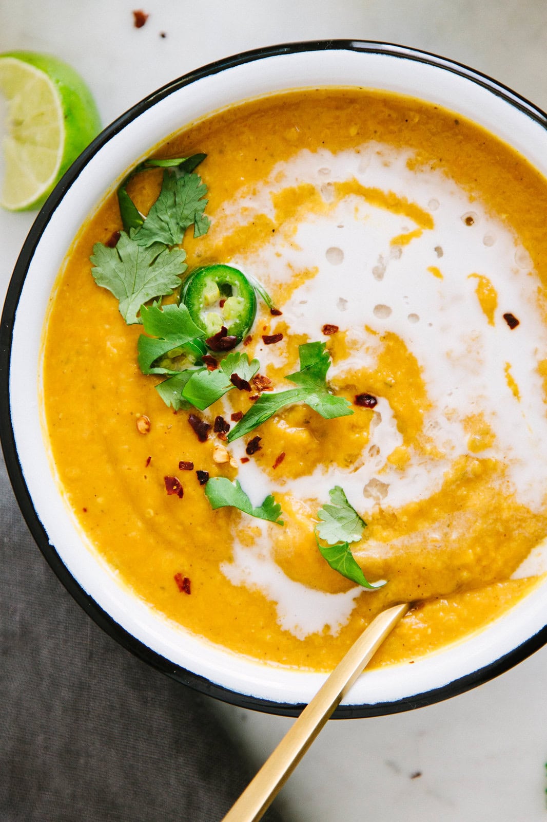 vegan puree soup of sweet potatoes and red lentils in a bowl with spoon.