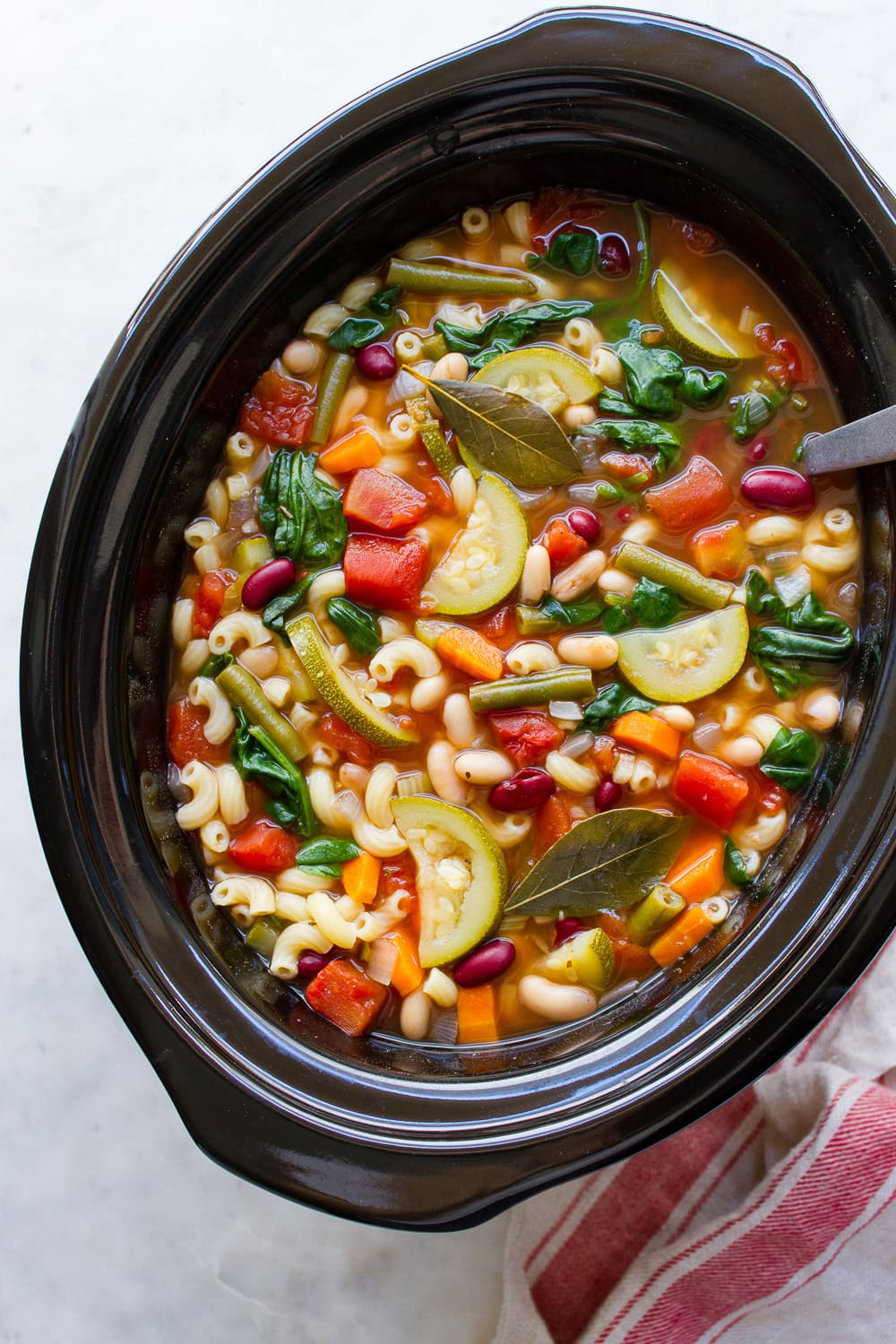 vegan slow cooker minestrone soup with beans and vegetables.