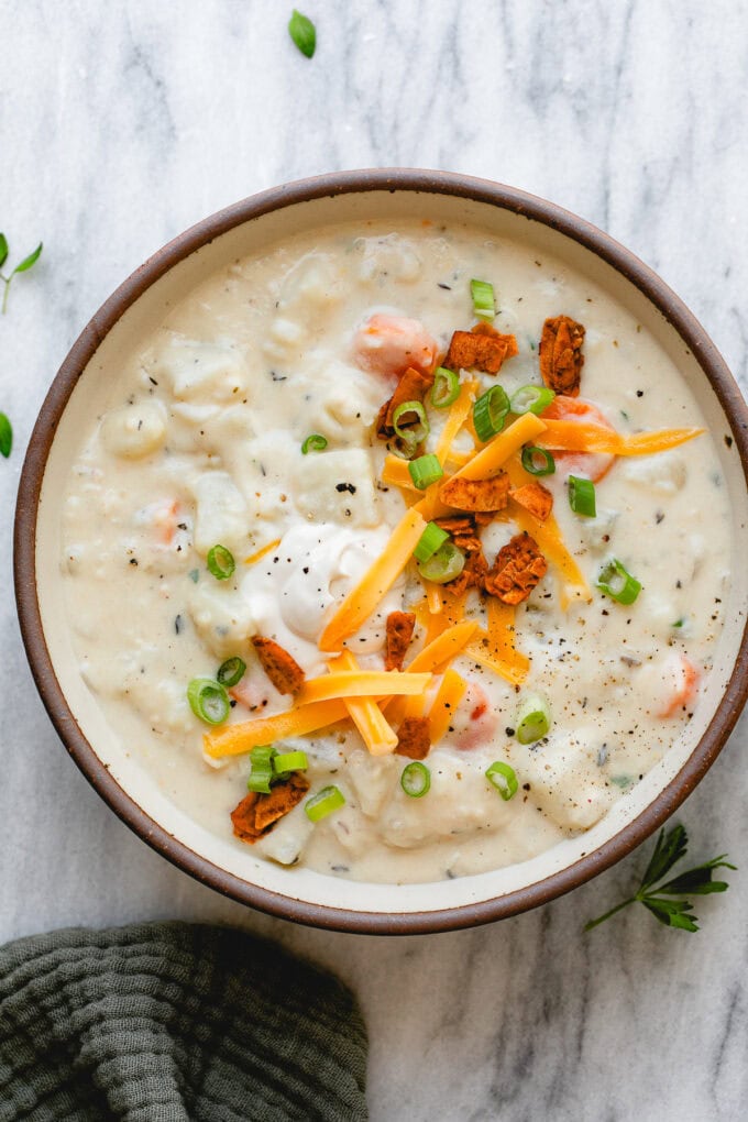top down view of bowl of vegan potato soup with topping.