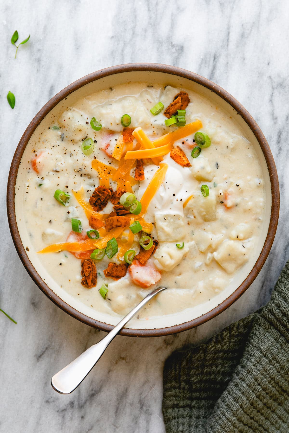 top down view of bowl of vegan potato soup with topping.