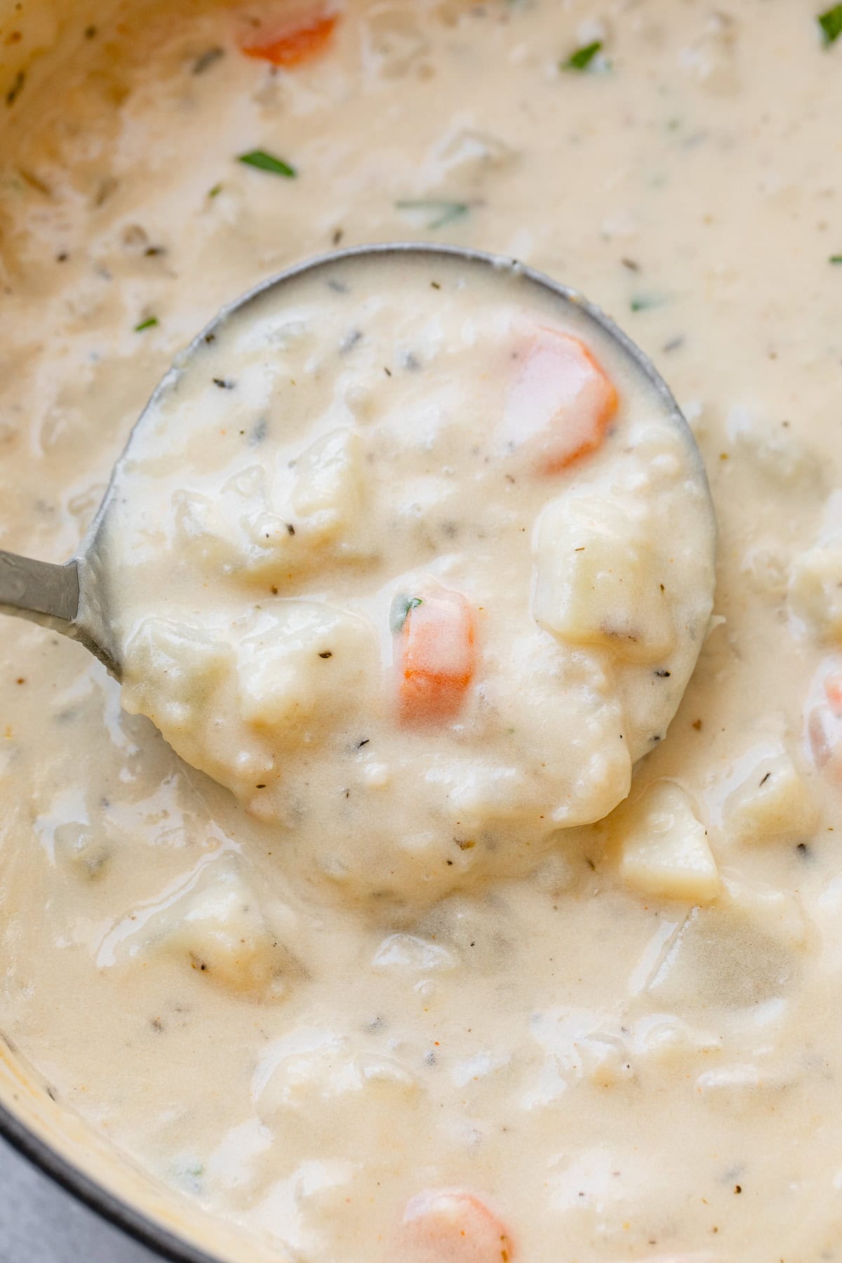 top down view of soup ladle filled with vegan potato soup.
