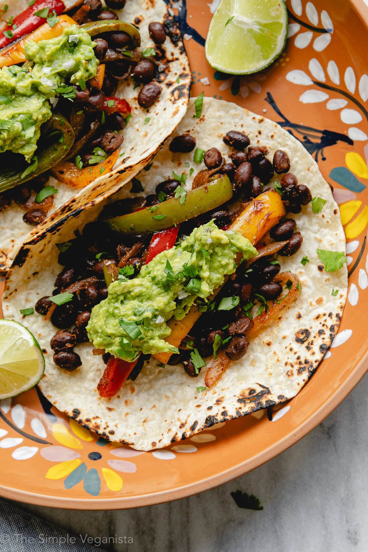 Black bean fajitas served in soft tortillas with avocado, cilantro, and lime.