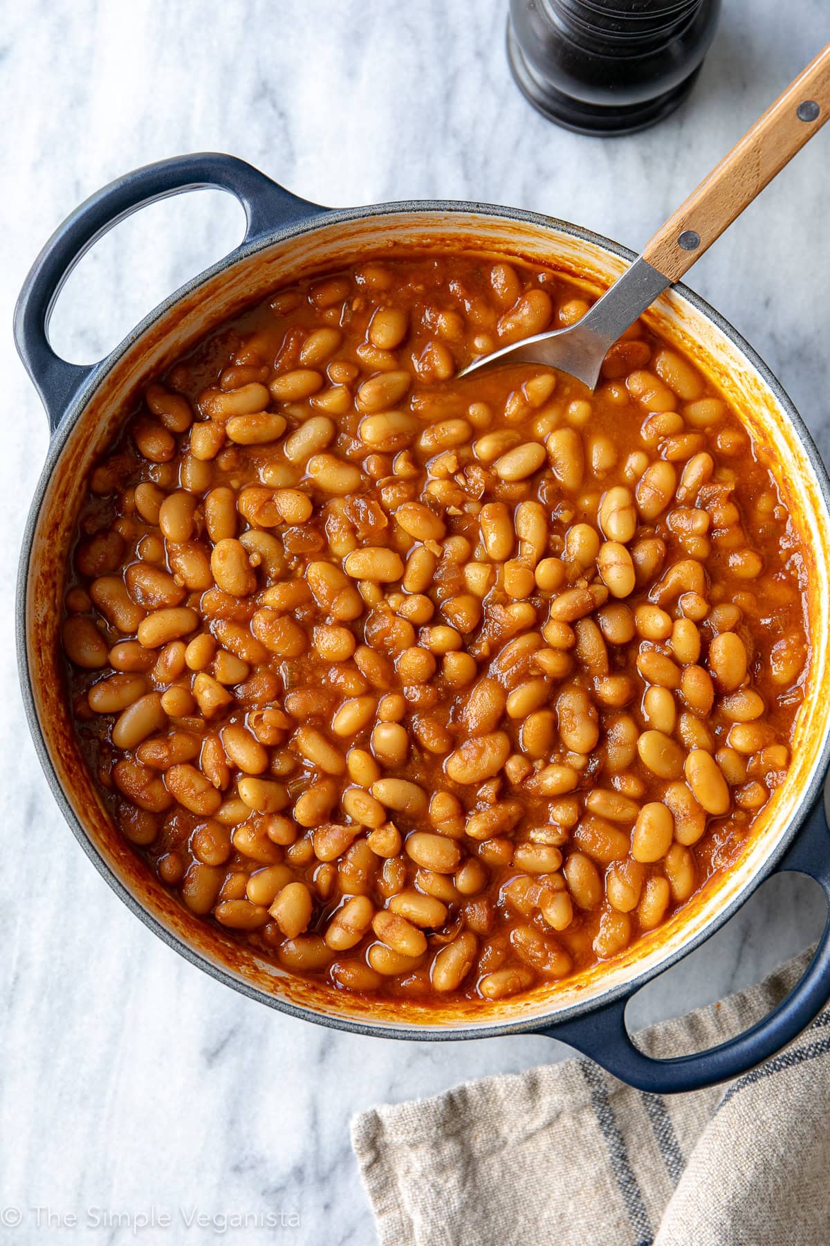 top down view of freshly vegan baked beans in a pot with spoon.